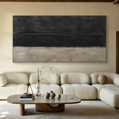 Handcrafted wabi-sabi Japandi abstract canvas artwork (AURA797), featuring a two-tone muted neutral palette of deep matte black and soft warm beige. The piece uses thick hand-applied impasto technique: upper black areas have scored, scraped pigment textures with a prominent raised horizontal impasto stripe across the middle, lower beige section has plaster-like aged, scratched, faded uneven surfaces. Minimalist textured abstract wall art for modern, minimalist, neutral industrial and Japandi home decor.