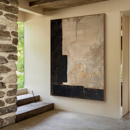 Wabi Sabi Japandi minimalist abstract canvas wall art, asymmetric geometric design hung above light oak entry console against soft neutral wall as welcoming entryway focal decor, large warm muted beige main field with natural weathered craquelure cracked texture, subtle warm tan undertones peeking through the plaster-like surface, bold matte black textured geometric blocks framing the left edge and bottom border, neutral tone tactile abstract wall art fitting perfectly with cozy relaxed modern, light wood t