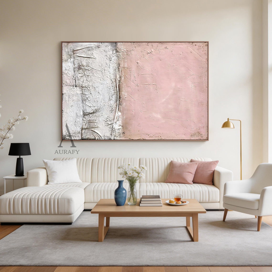 WABI SABI Pink Abstract Textured Wall Art (AURA245) - Soft Blush Upper Half with Visible Brush Strokes & Imperfections, Lower Half in White & Neutral Cracked Layered Finish. Framed in Thin Light Wood Frame. Displayed in Modern Serene Bedroom: Beige Linen Bedding, Light Wood Nightstand with White Ceramic Table Lamp, Small Potted Green Succulent, Warm Yellow Wall Sconce Glow. Perfect for Minimalist Home Decor, Wabi Sabi Inspired Living Space Accent, Cozy Bedroom Wall Decor. AURA245 Collection Merges Wabi Sabi